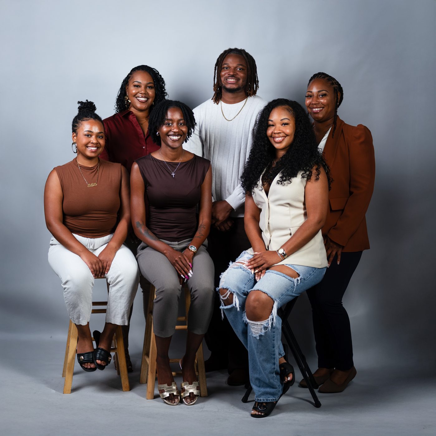 The Threshold Social founder and founding board together in a studio portrait — three seated on stools in front, three standing behind them.